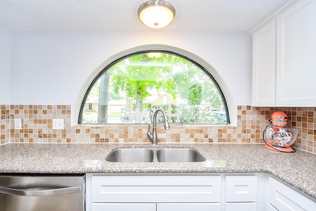 kitchen featuring white cabinetry, a healthy amount of sunlight, a sink, and dishwasher