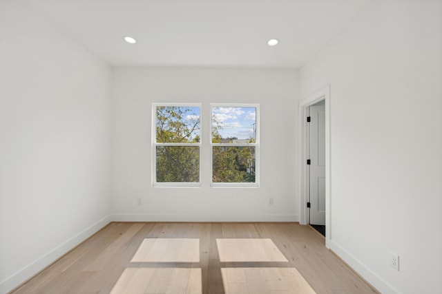 spare room with recessed lighting, light wood finished floors, and baseboards