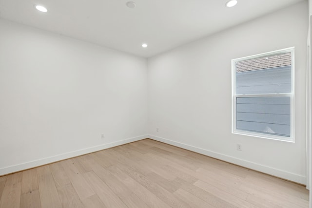 empty room featuring recessed lighting, baseboards, and light wood-type flooring