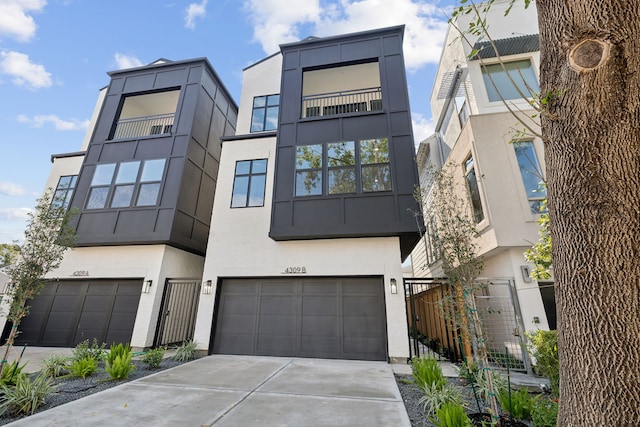 modern home featuring a garage, driveway, and stucco siding