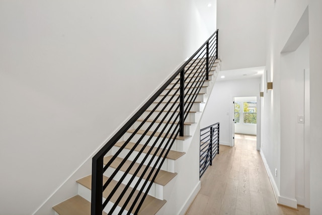 stairs featuring hardwood / wood-style flooring, baseboards, and recessed lighting