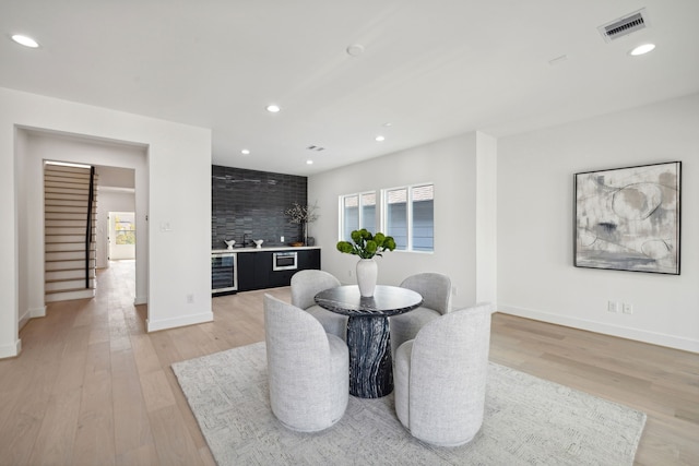 dining space with recessed lighting, wine cooler, visible vents, light wood-type flooring, and indoor wet bar