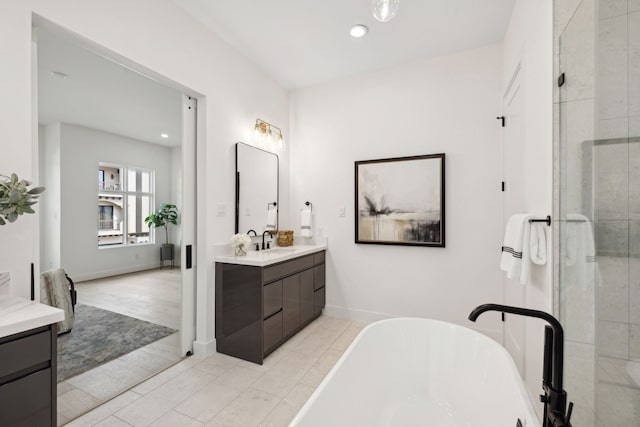 full bath with a freestanding bath, tiled shower, vanity, and recessed lighting