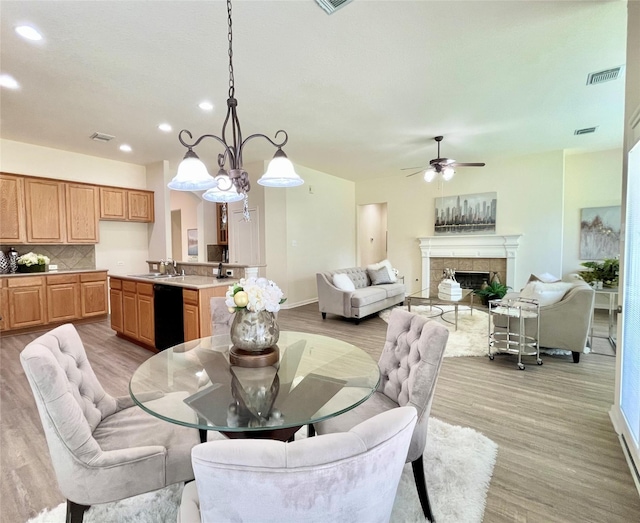 26936 Chateau Lake Dr, Kingwood, TX 77339 - dining room featuring light wood-type flooring, a tiled fireplace, visible vents, and ceiling fan