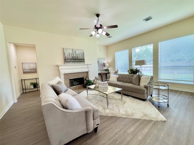 26936 Chateau Lake Dr, Kingwood, TX 77339 - living room with a tile fireplace, wood finished floors, visible vents, a ceiling fan, and baseboards