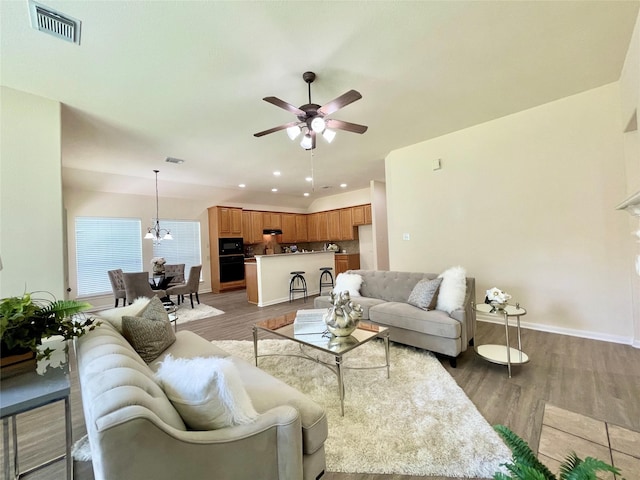 26936 Chateau Lake Dr, Kingwood, TX 77339 - living room with light wood-style flooring, visible vents, baseboards, and ceiling fan with notable chandelier