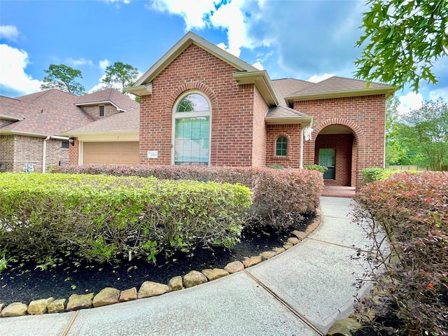 26936 Chateau Lake Dr, Kingwood, TX 77339 - view of front of property featuring an attached garage, brick siding, and roof with shingles