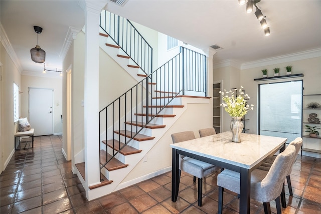 dining space featuring track lighting, crown molding, stairs, and visible vents