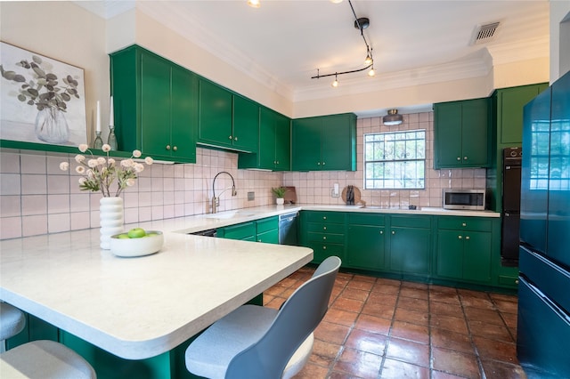kitchen with light countertops, visible vents, a sink, stainless steel microwave, and a peninsula