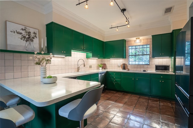 kitchen featuring a peninsula, light countertops, a sink, and green cabinetry