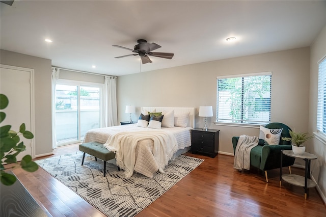 bedroom with wood finished floors, access to outside, and multiple windows