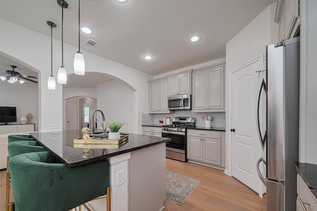 12205 Renewal Way, Houston, TX 77047 - kitchen with appliances with stainless steel finishes, arched walkways, light wood-style floors, a ceiling fan, and open floor plan