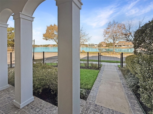 view of patio / terrace featuring fence and a water view