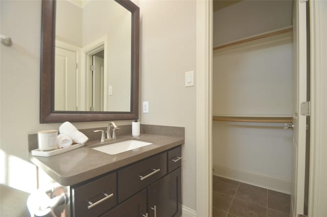 bathroom with tile patterned flooring, baseboards, and vanity