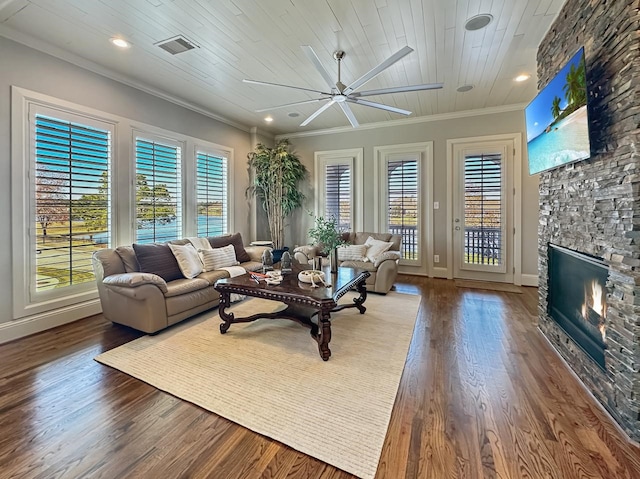 living room featuring a healthy amount of sunlight, a fireplace, visible vents, and ceiling fan
