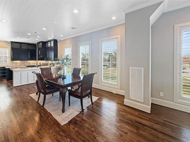 dining area with dark wood-style flooring, crown molding, visible vents, and a wealth of natural light