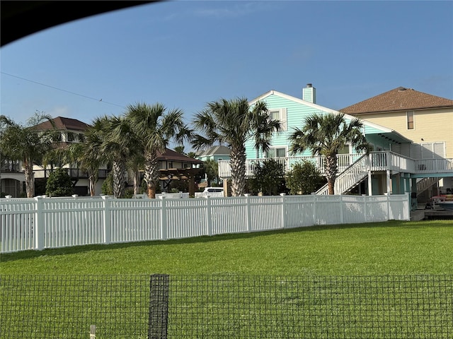 view of yard with fence and stairs