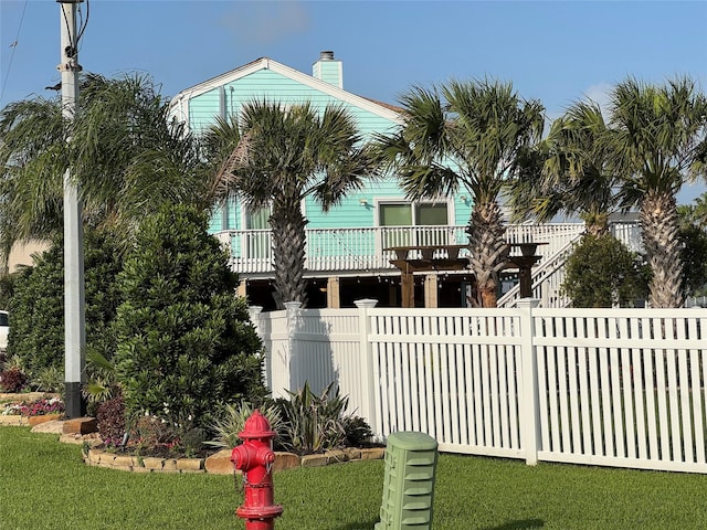 exterior space featuring a chimney, a front yard, and fence private yard