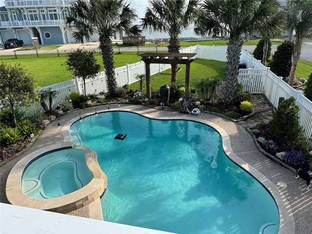 view of swimming pool featuring a yard, a pool with connected hot tub, and a fenced backyard