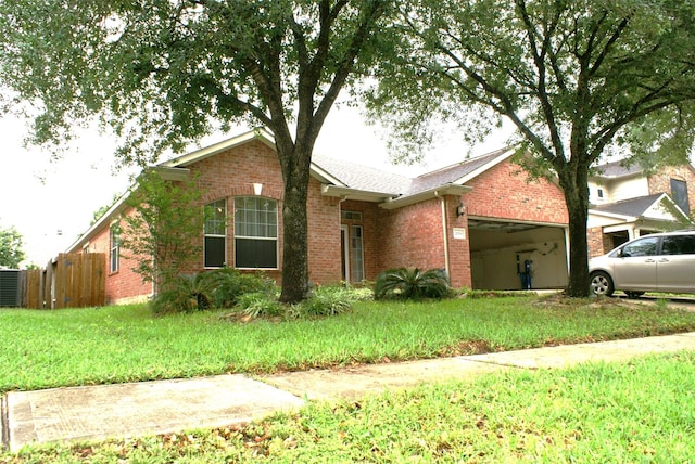 ranch-style house with a front yard, fence, an attached garage, and brick siding