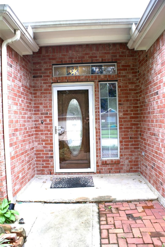 view of exterior entry with brick siding