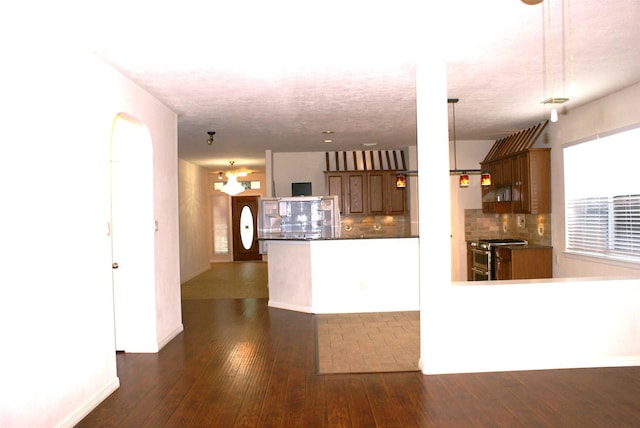 kitchen featuring dark wood-style floors, brown cabinetry, backsplash, and double oven range