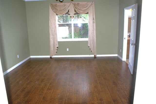 empty room with dark wood-style floors, baseboards, and ceiling fan