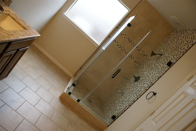 interior details with a stall shower, vanity, and baseboards