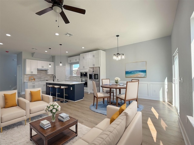 16366 Eastchase St, Montgomery, TX 77316 - living area with recessed lighting, light wood-style floors, visible vents, and ceiling fan with notable chandelier
