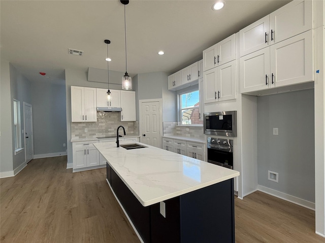 16366 Eastchase St, Montgomery, TX 77316 - kitchen with white cabinets, stainless steel appliances, a sink, visible vents, and decorative backsplash