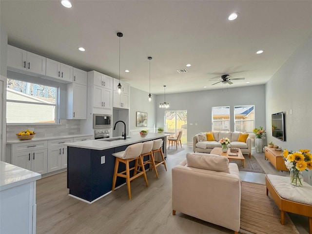 16366 Eastchase St, Montgomery, TX 77316 - kitchen with a sink, open floor plan, stainless steel appliances, white cabinetry, and recessed lighting