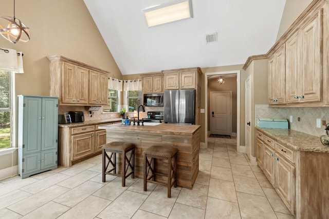 kitchen with tasteful backsplash, a healthy amount of sunlight, stainless steel appliances, visible vents, and high vaulted ceiling