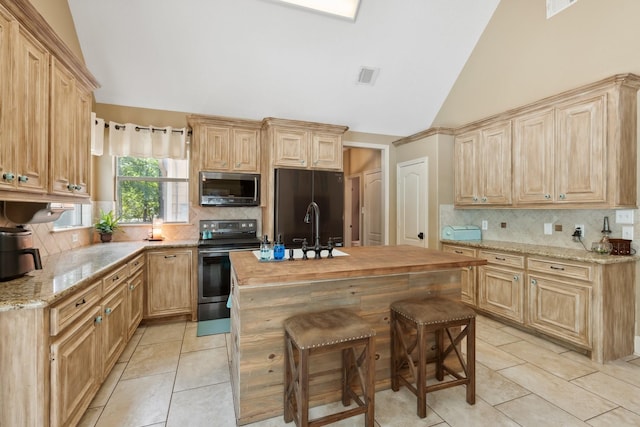 kitchen featuring appliances with stainless steel finishes, light tile patterned floors, visible vents, and decorative backsplash