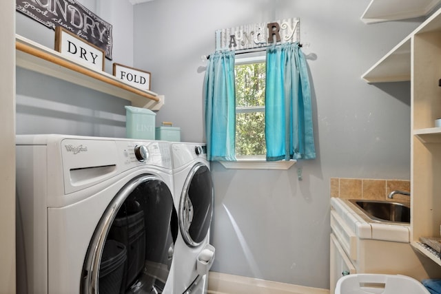 laundry room with baseboards, washing machine and clothes dryer, laundry area, and a sink