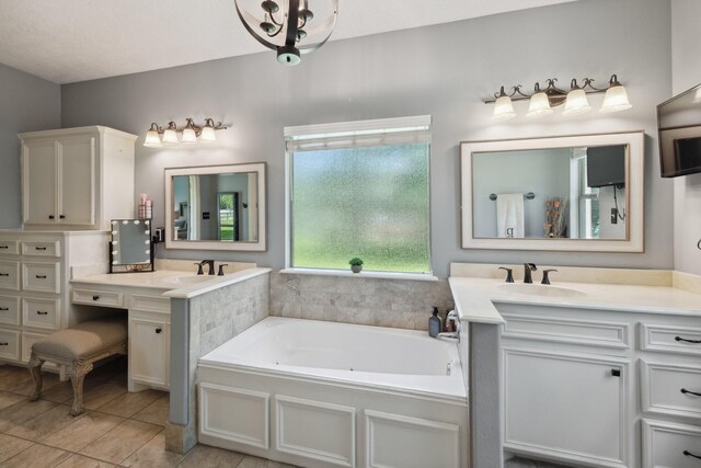 bathroom featuring tile patterned flooring, a bath, two vanities, and a sink