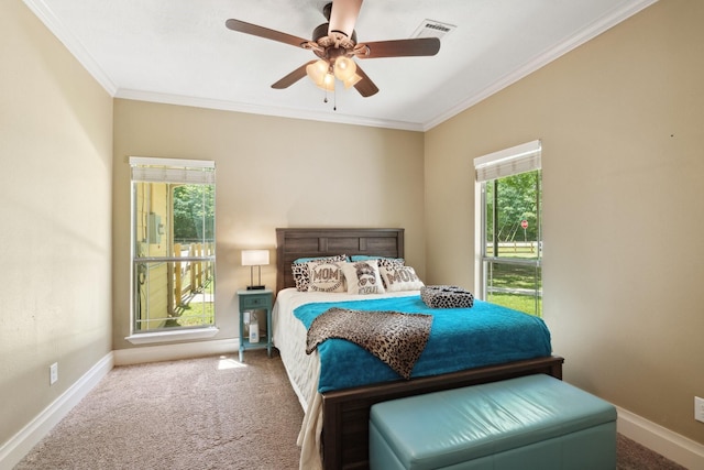 carpeted bedroom featuring baseboards, visible vents, ornamental molding, and a ceiling fan
