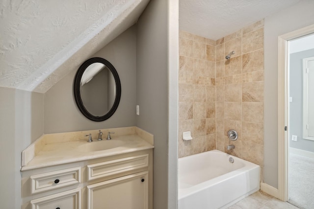 bathroom with a textured ceiling, shower / washtub combination, and vanity