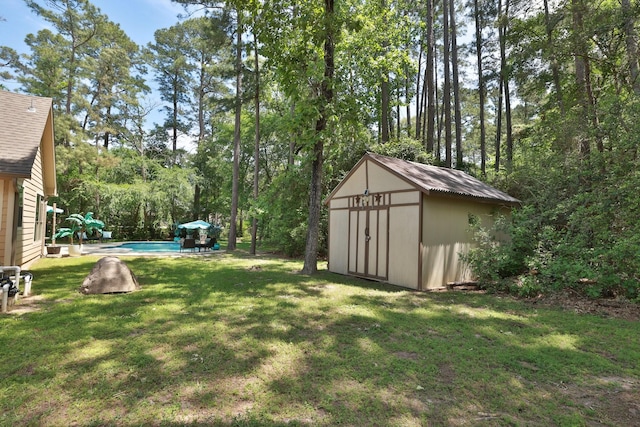 view of yard with an outdoor structure, a shed, and an outdoor pool
