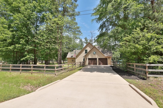 view of front facade featuring concrete driveway and fence private yard