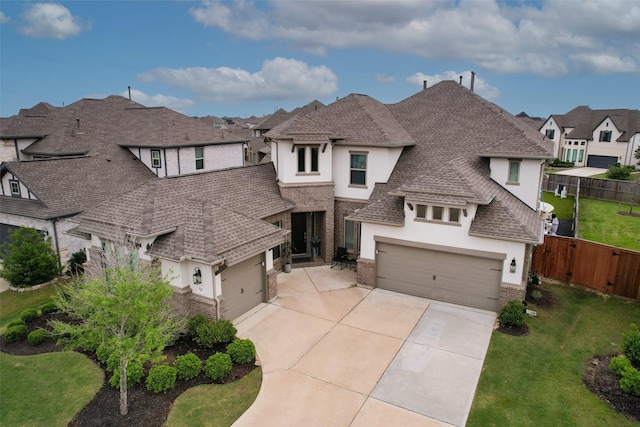view of front facade featuring stucco siding, fence, a residential view, and concrete driveway