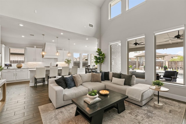 living room with visible vents, ceiling fan, wood finished floors, and a wealth of natural light