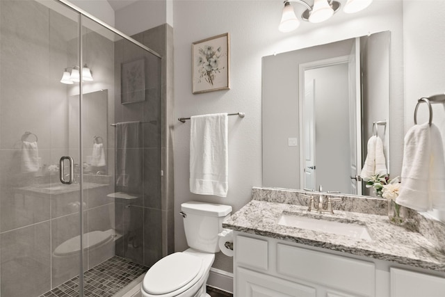 full bath featuring vanity, a stall shower, and toilet
