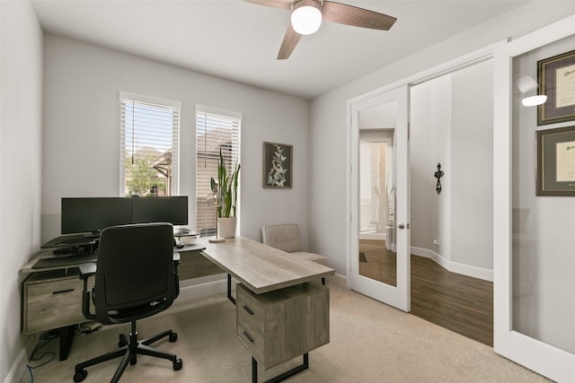 carpeted home office featuring french doors, baseboards, and ceiling fan