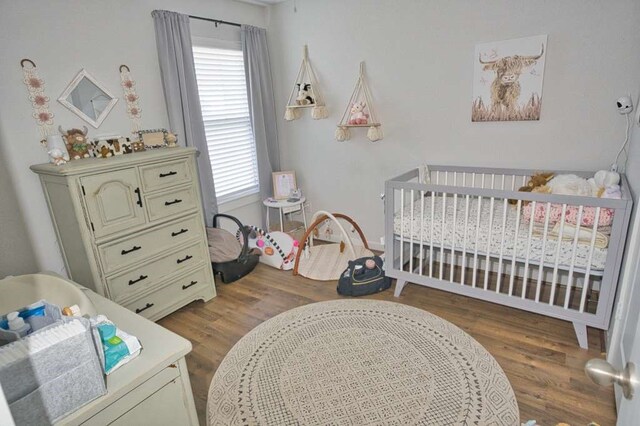 219 Lisa Marie Dr, Angleton, TX 77515 - bedroom featuring a nursery area and wood finished floors