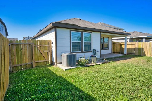 219 Lisa Marie Dr, Angleton, TX 77515 - back of property featuring a lawn, a fenced backyard, a patio area, and cooling unit