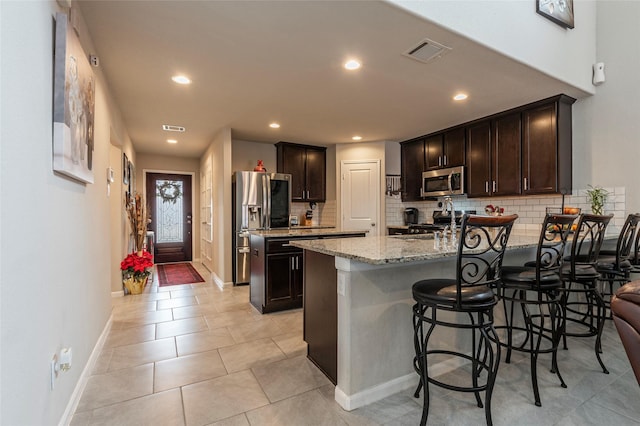 2214 Del Mar Dr, Texas City, TX 77568 - kitchen with a peninsula, dark brown cabinetry, stainless steel appliances, and visible vents