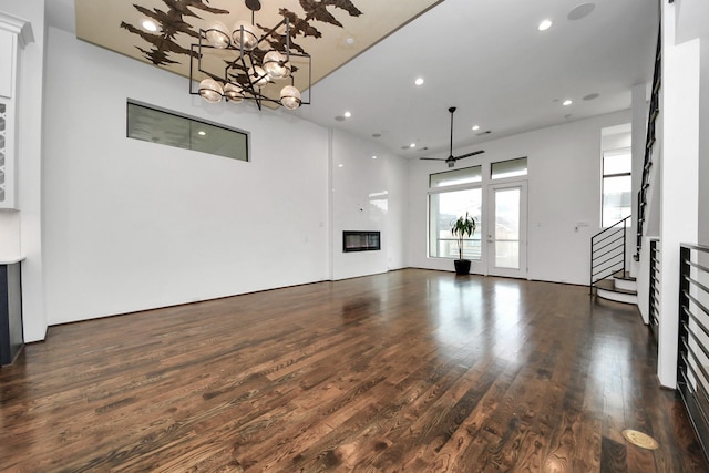 1512 Malone St, Houston, TX 77007 - unfurnished living room featuring dark wood finished floors, recessed lighting, ceiling fan with notable chandelier, a glass covered fireplace, and stairway