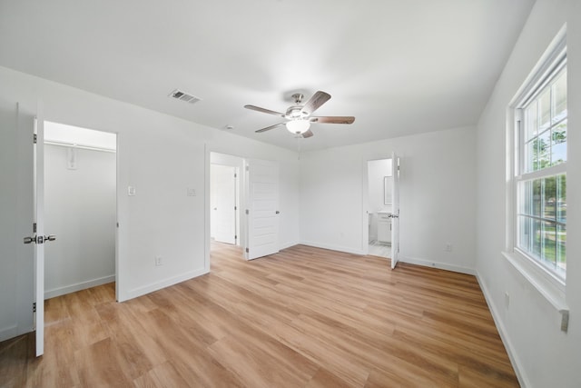 9711 Derrik Dr, Houston, TX 77080 - unfurnished bedroom featuring a walk in closet, light wood-type flooring, visible vents, and baseboards