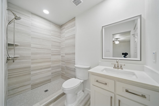 9711 Derrik Dr, Houston, TX 77080 - bathroom with vanity, ceiling fan, toilet, visible vents, and tiled shower