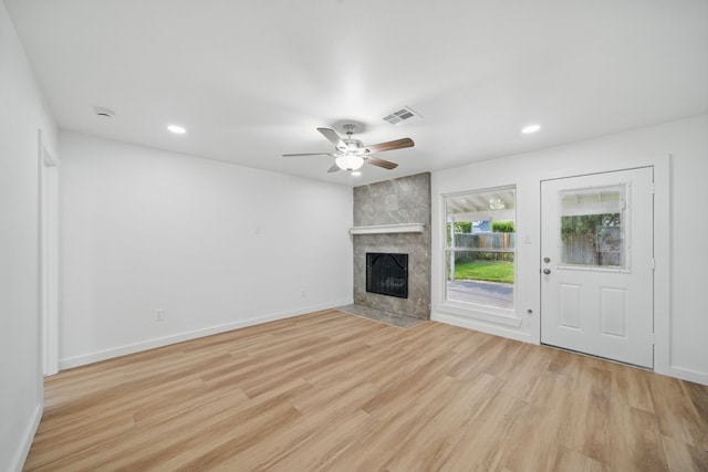 9711 Derrik Dr, Houston, TX 77080 - unfurnished living room featuring a tile fireplace, visible vents, light wood-type flooring, baseboards, and ceiling fan